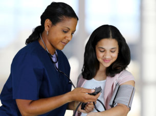 nurse checking a woman's blood pressure